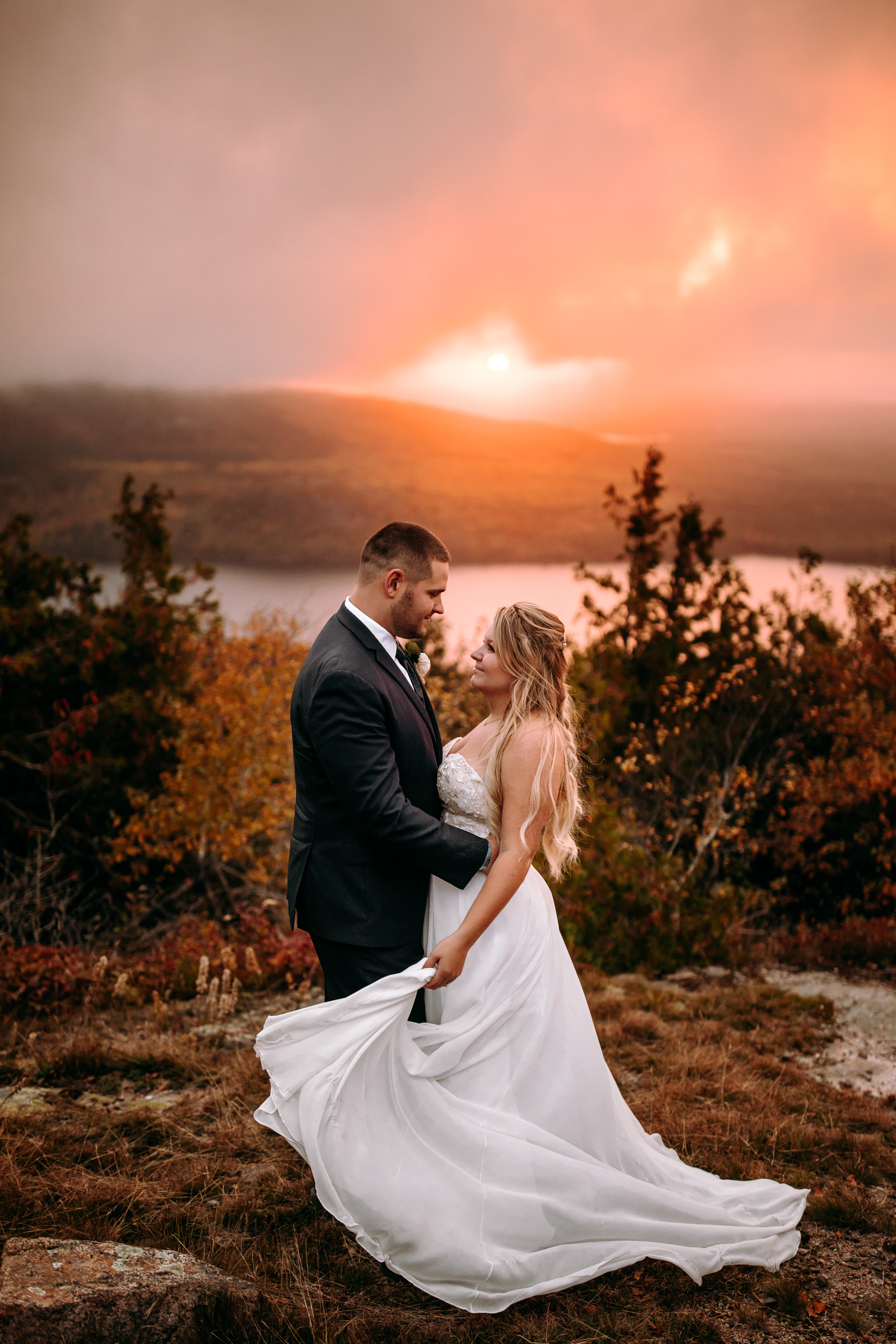 Couple on top of Cadillac Mountain in Bar Harbor Maine at Acadia national park during their fall elopement in Maine at sunset candid documentary style photographer