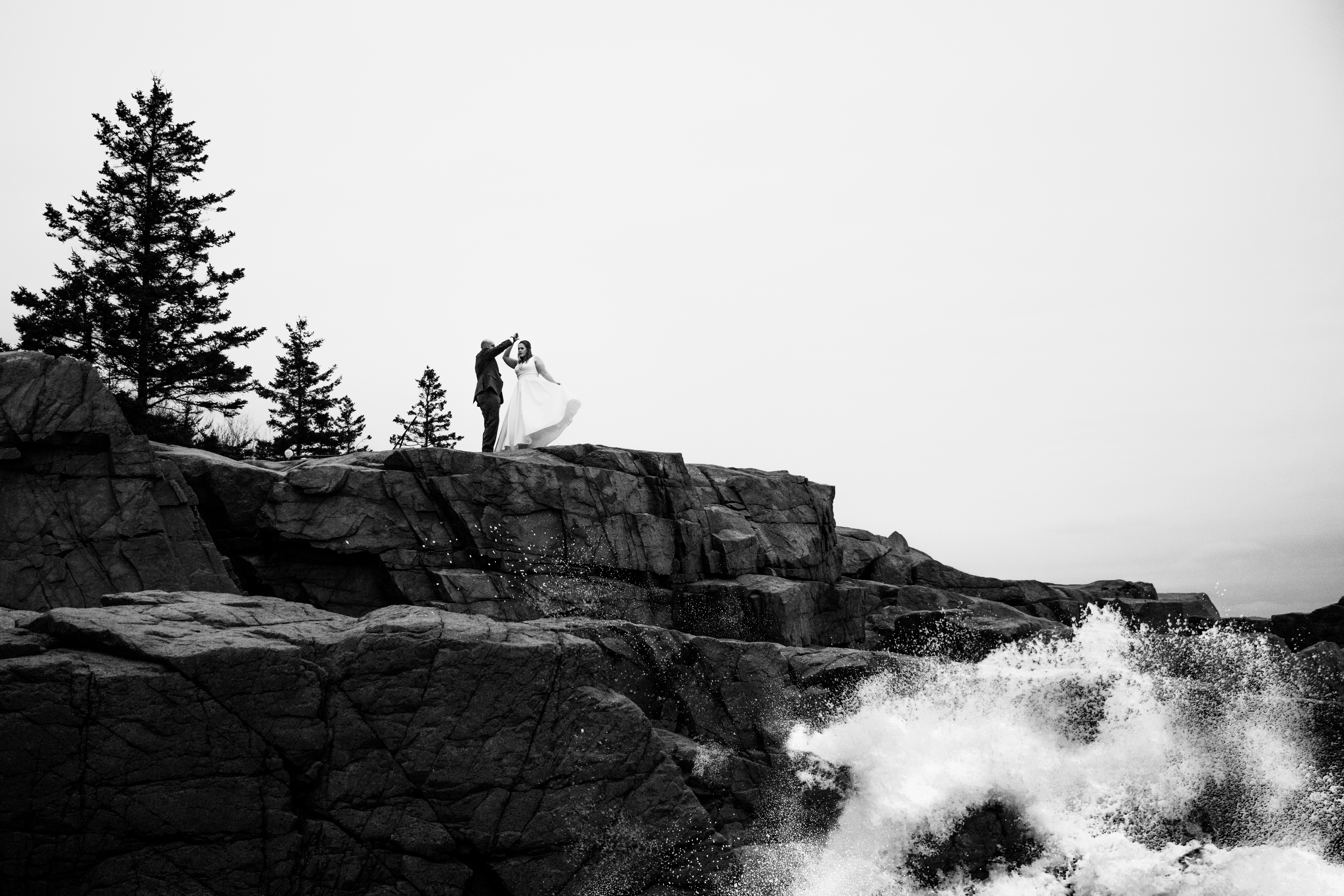 Bride and groom on Otter Cliffs in Acadia National Park during their elopement in Bar Harbor Maine waves crashing against the rocks by Thunder Hole