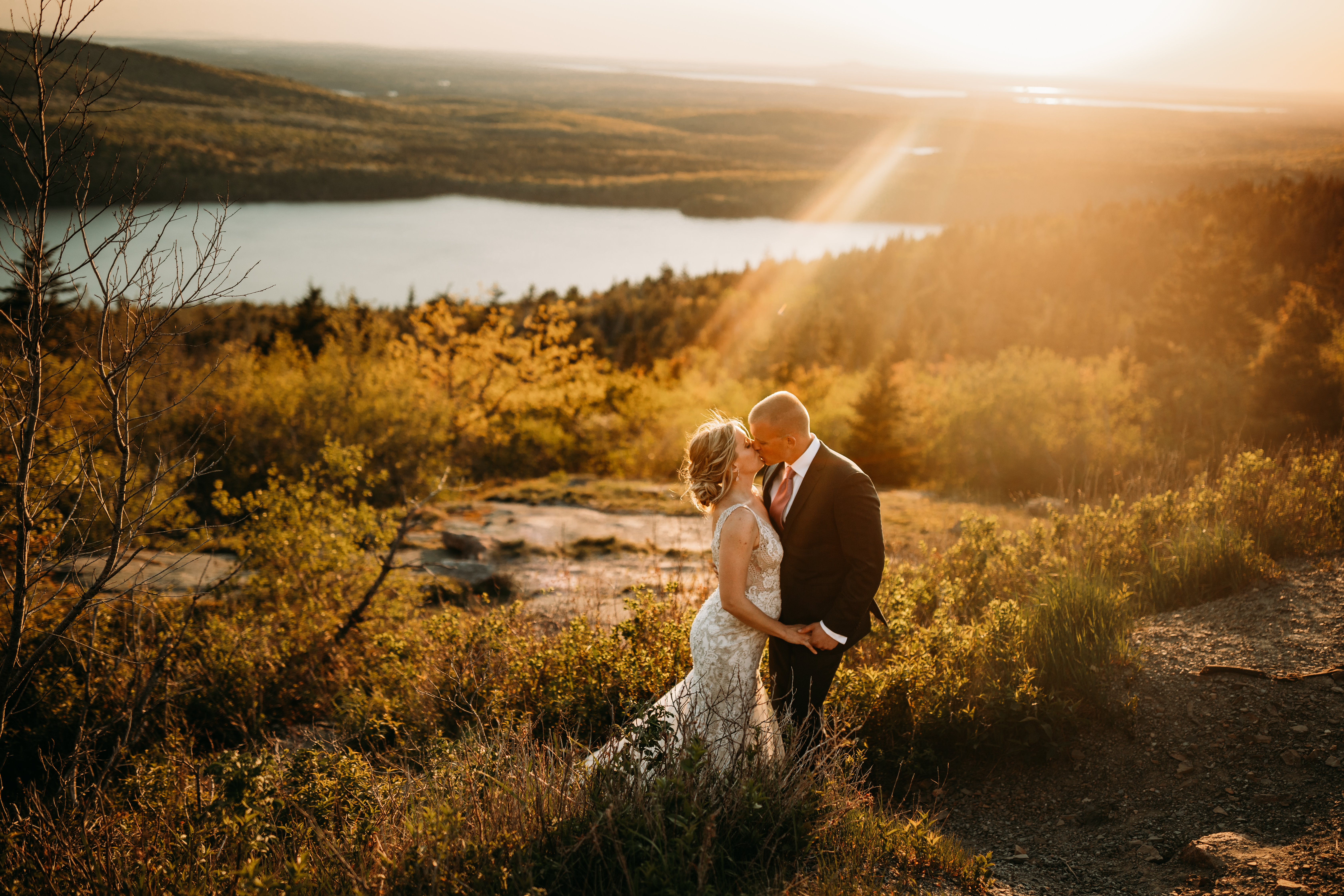 Wedding bride and groom on top of Cadillac Mountain and sunset in Acadia National Park with Bar Harbor downtown and Echo Lake in the background Emily Leonard Photography Maine wedding and elopement photographer