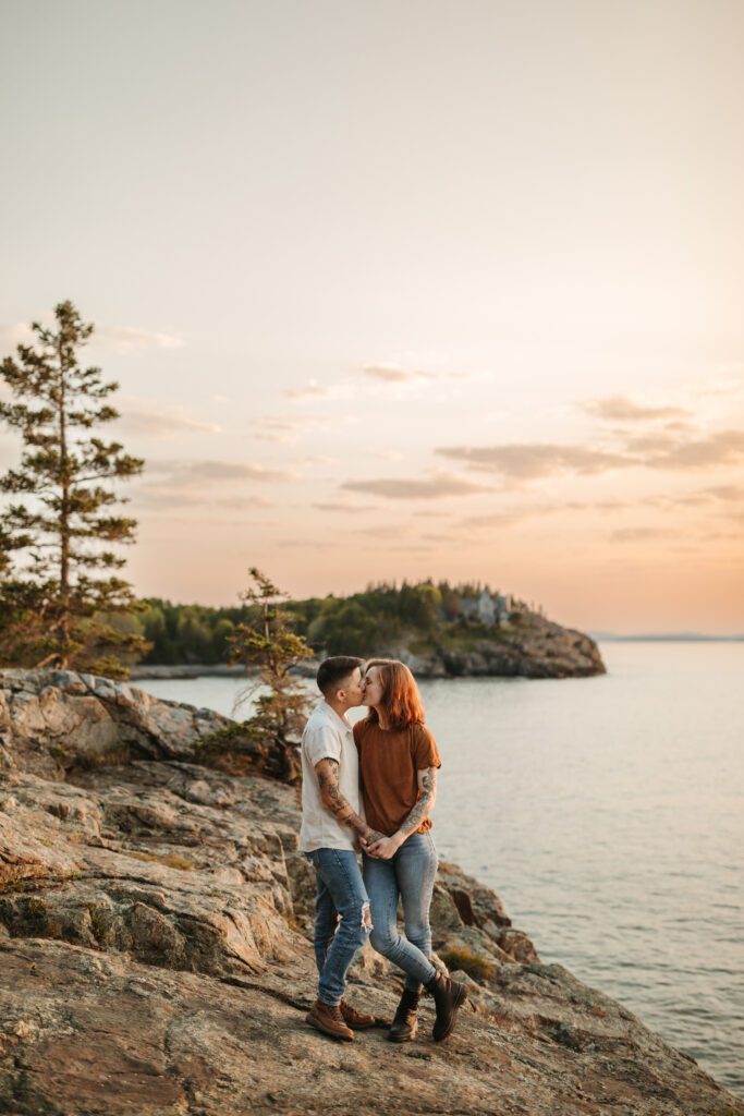 lesbian couple kissing during their sunrise proposal session in Acadia National Park, Maine