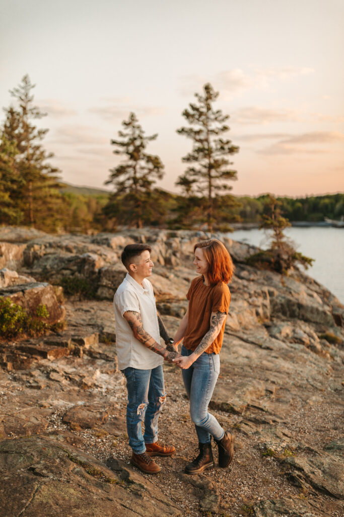 couple holding hands on the cliffside in acadia national park otter cliffs for sunrise 