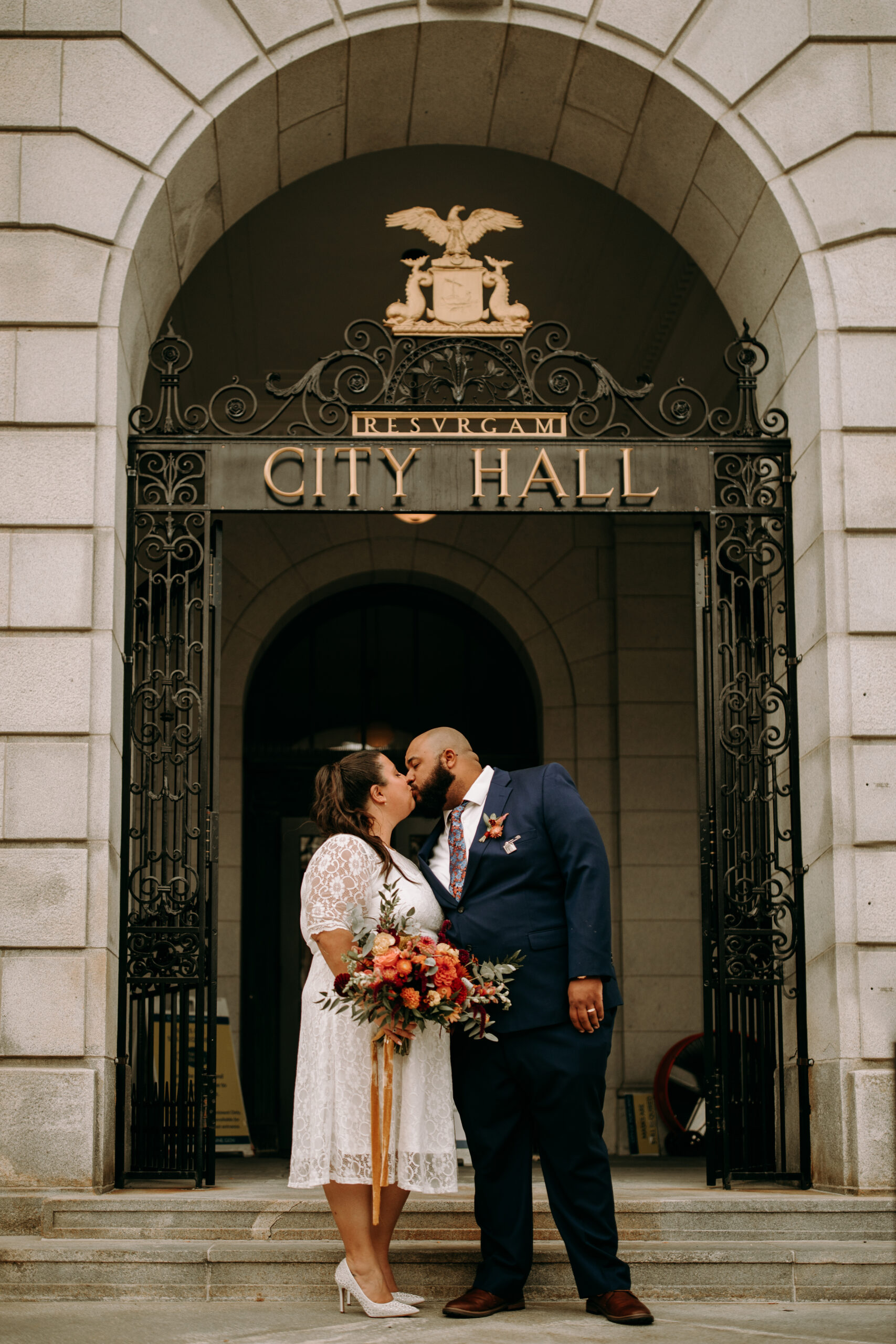Bride and groom exchange a kiss on the front steps of Portland City Hall for the celebration of their elopement in the Old Port in Portland Maine