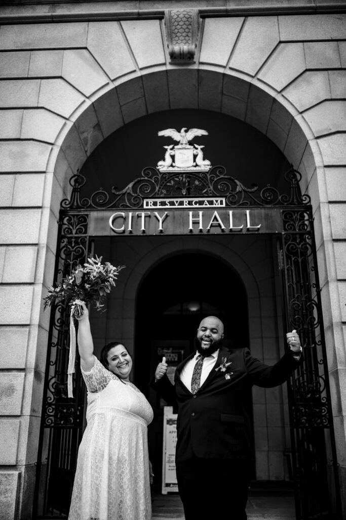 Fun cheers elopement photo in Portland Maine City Hall
