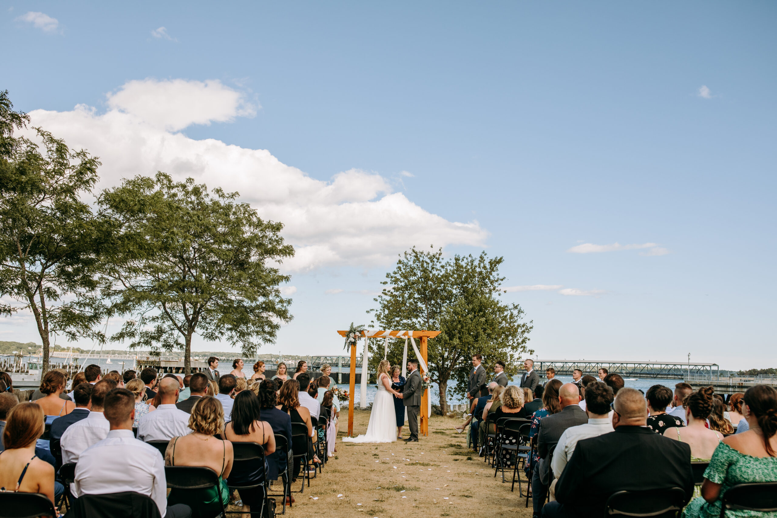 ceremony with bride and groom at Portland Ocean Gateway overlooking the portland maine harbor