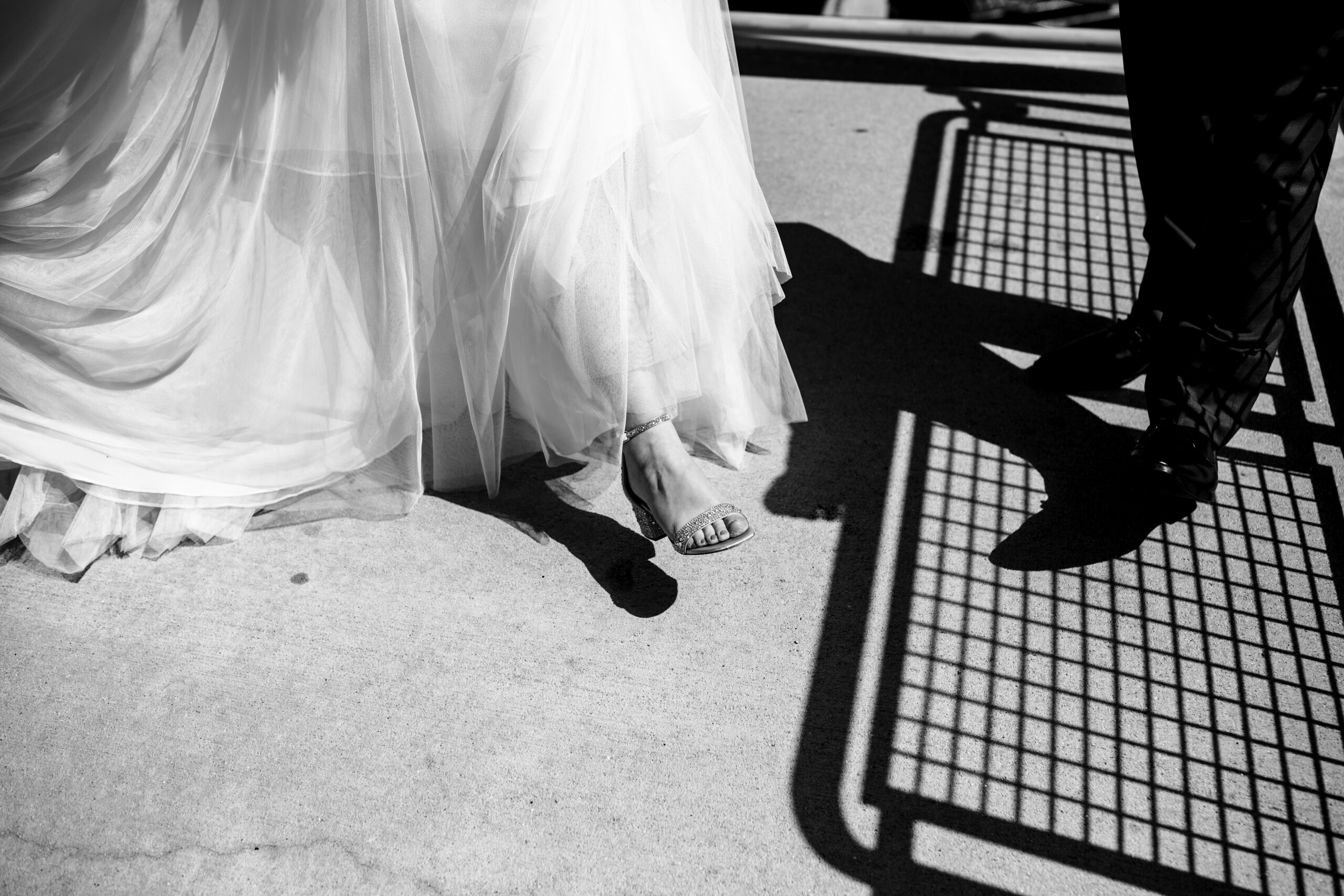 bride shows off her shoes to her groom during first look 