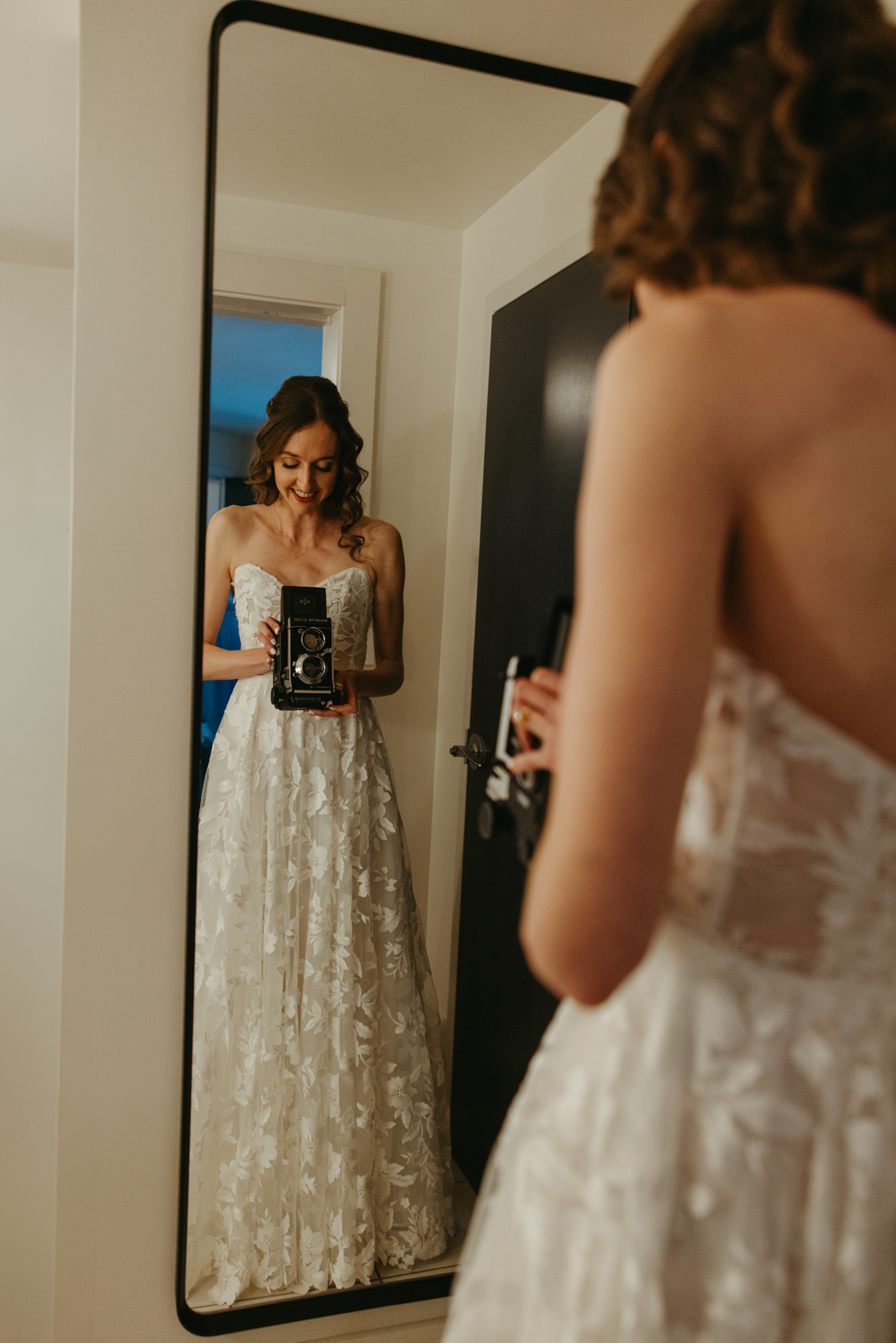 bride uses vintage camera for selfie at the cliff house maine while she gets ready for her wedding day 