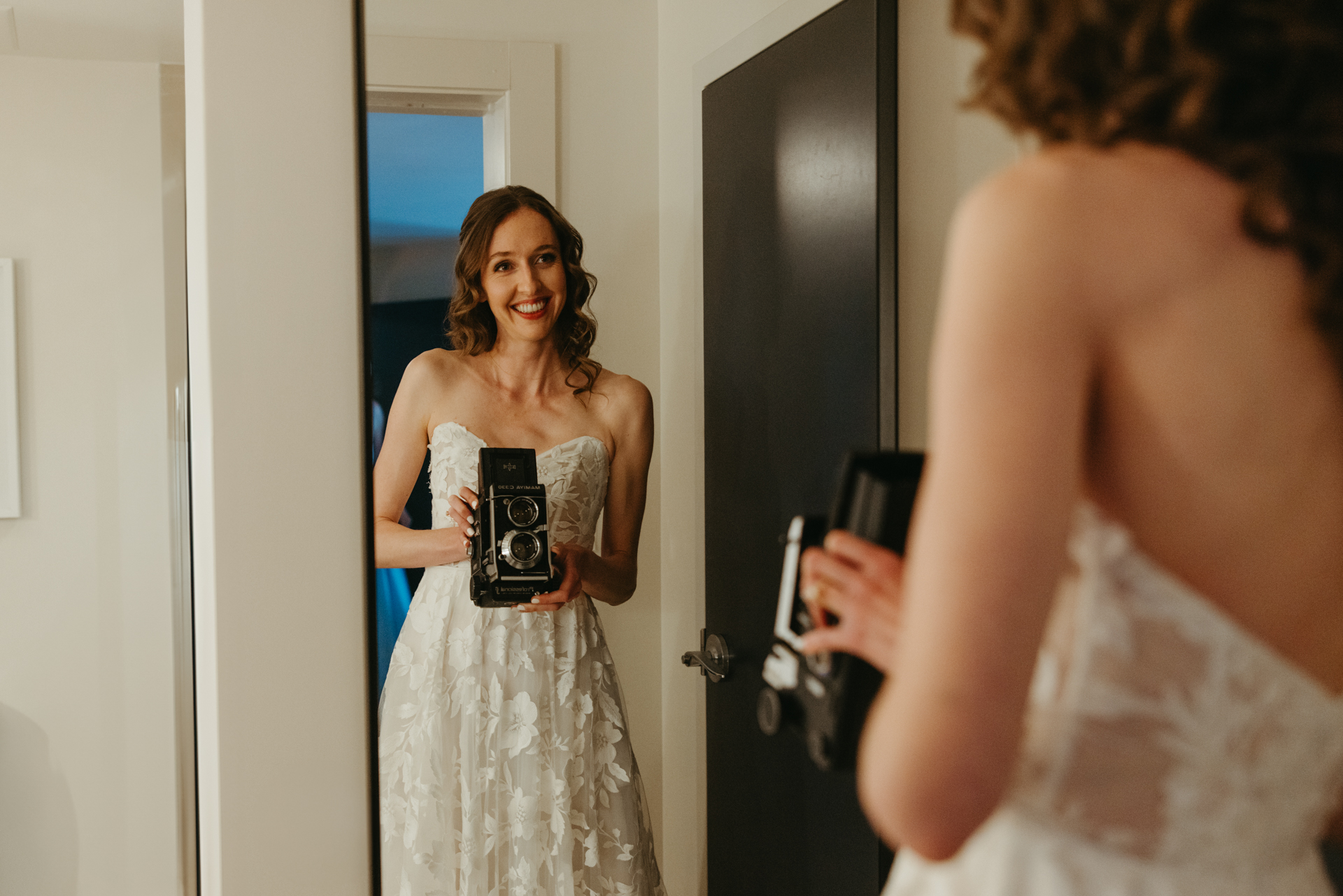 bride uses vintage camera for selfie at the cliff house maine while she gets ready for her wedding day 