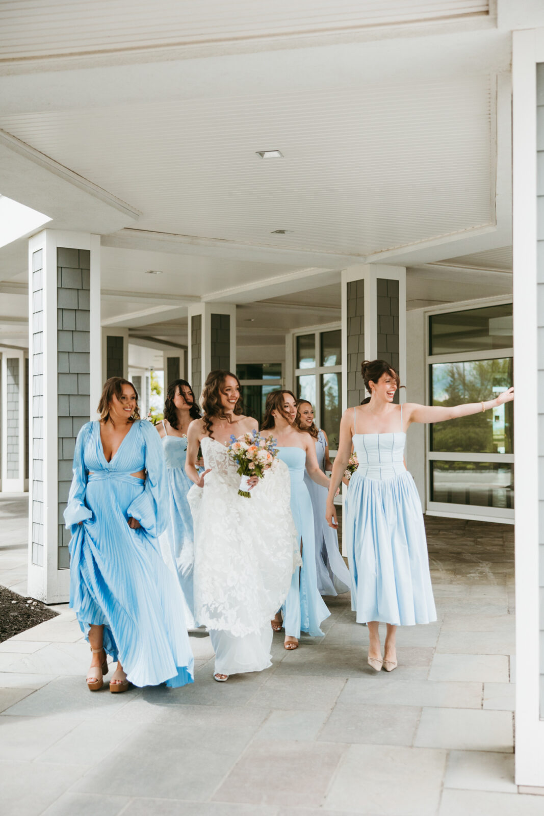 candid moment of bridesmaids walking towards the first look with the bride at the cliff house wedding venue in maine 