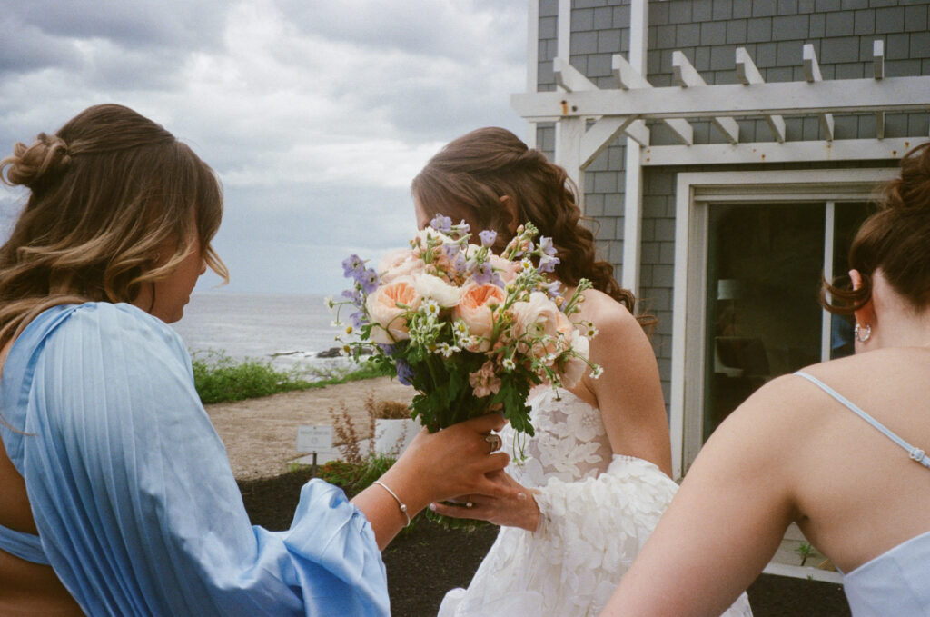 35mm film photo of bridesmaid handing the bride her flowers 