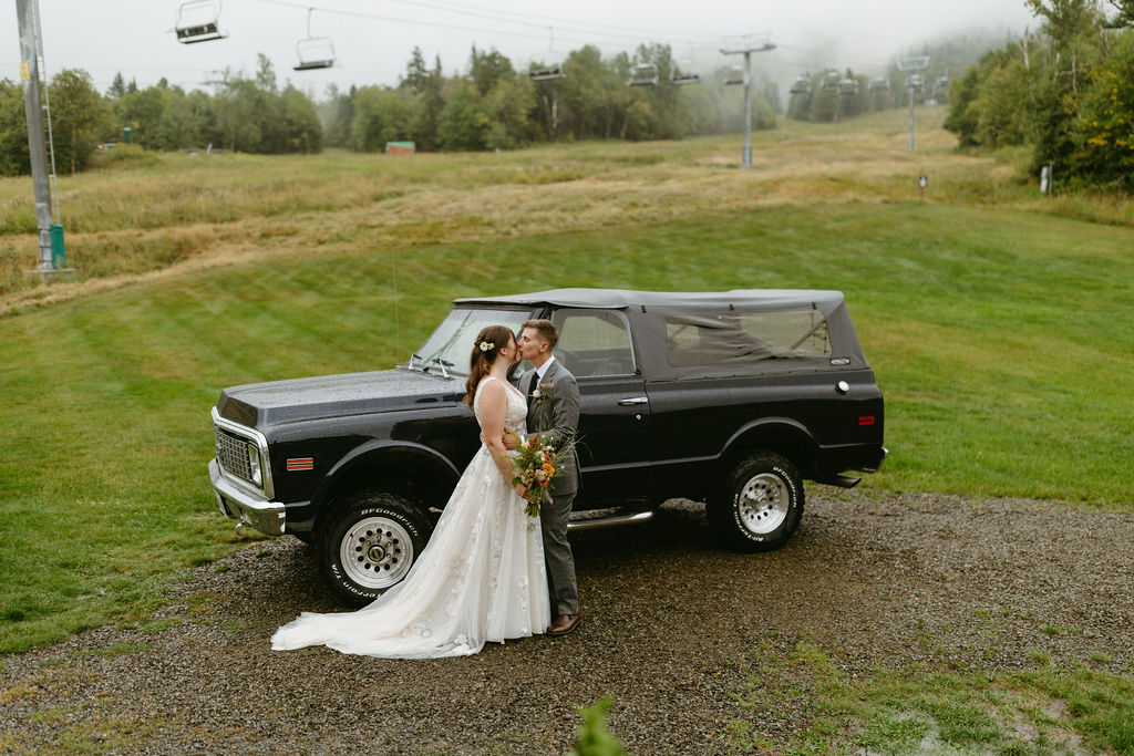 brides kissing with ski lift behind them at saddleback mountain in rangeley maine 