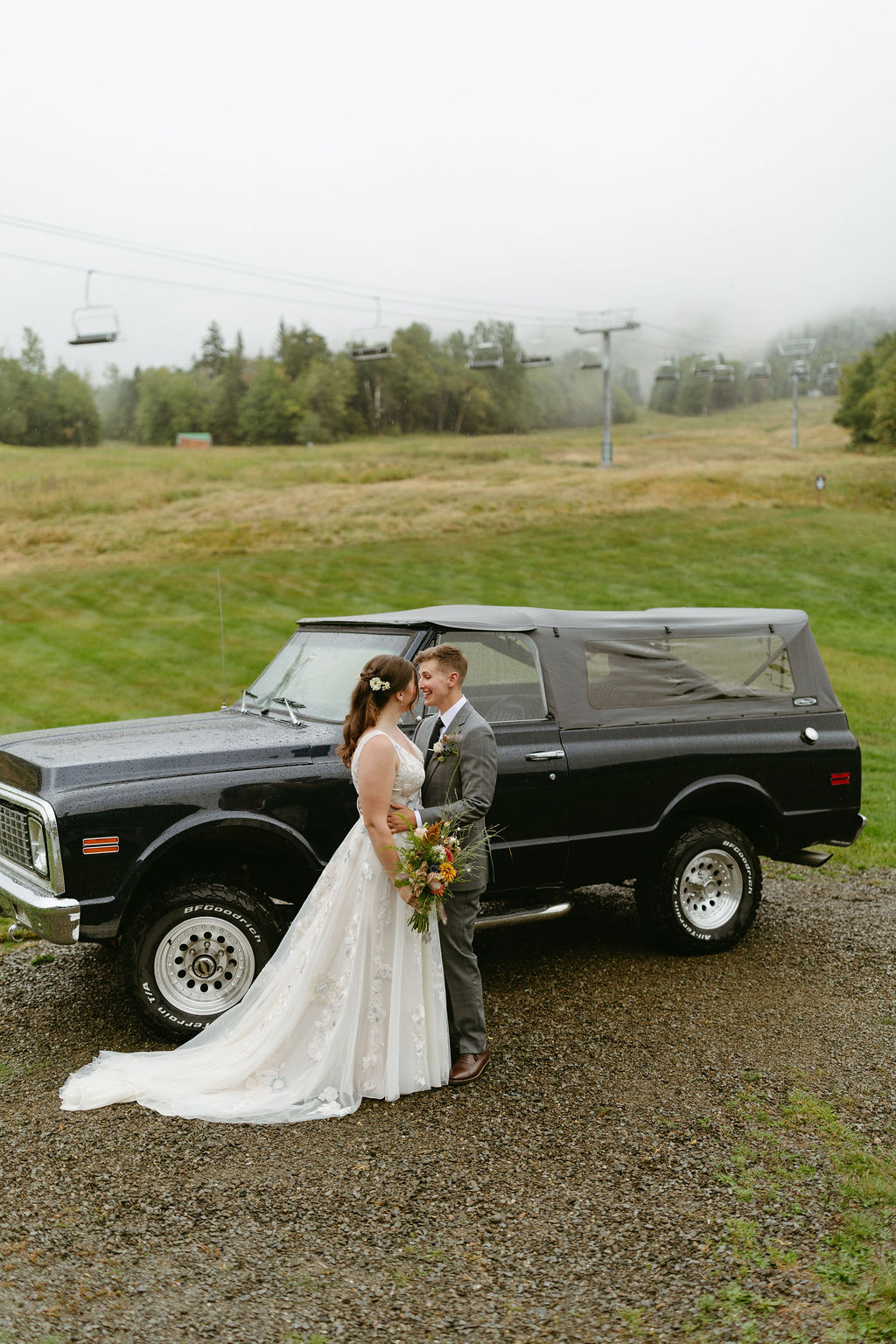 brides looking at each other with ski lift behind them at saddleback mountain in rangeley maine 