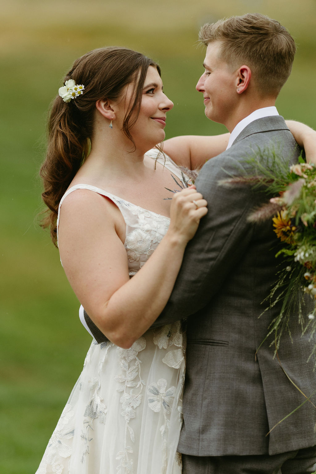 brides looking at each other with ski lift mountain behind them at Saddleback Mountain in Rangeley, Maine 