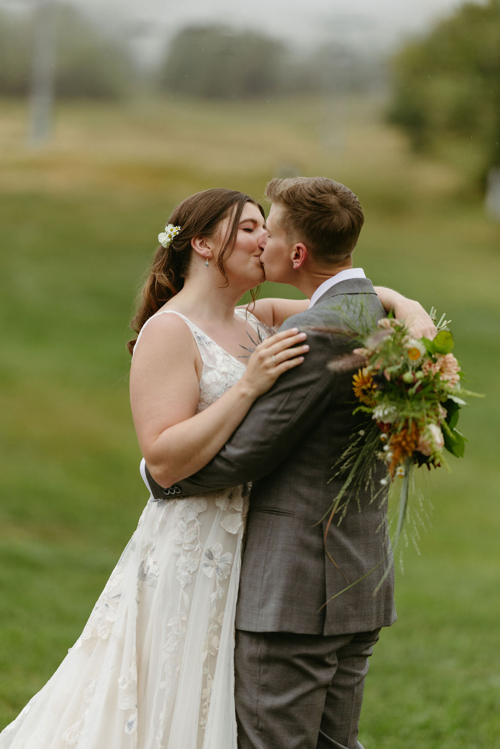 brides kissing with ski lift mountain behind them at Saddleback Mountain in Rangeley, Maine 
