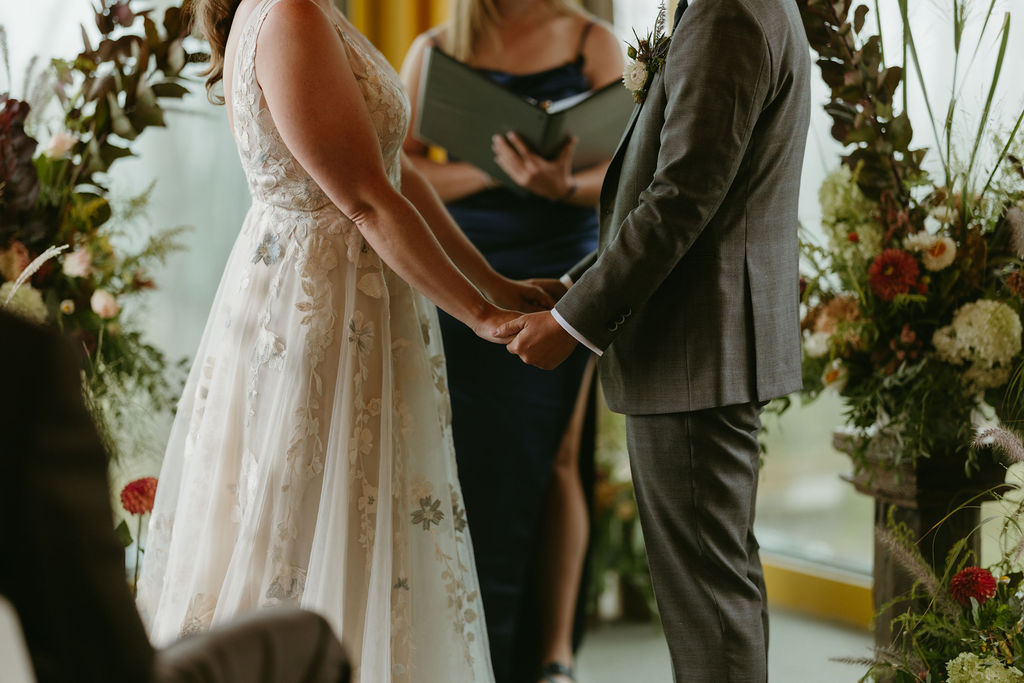 Photo of brides holding hands at a ceremony at The Nest at Saddleback Mountain Ski Resort in Rangeley, Maine for a wedding ceremony