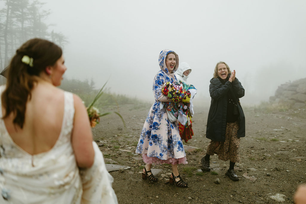 Wedding guests cheering for bride as they walk in the rain at Saddleback Mountain Wedding