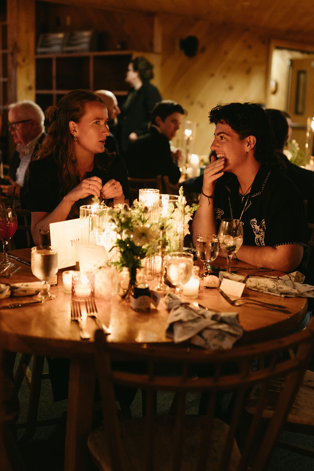 documentary style photograph of a couple laughing at a wedding reception at Saddleback Mountain wedding venue in Maine 